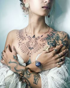 a woman with tattoos on her chest and arms