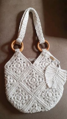 a white crocheted purse with wooden handles