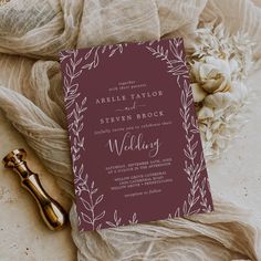 a wedding card on top of a table next to flowers