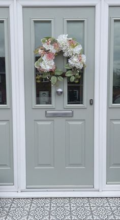 the front door is decorated with flowers and wreaths