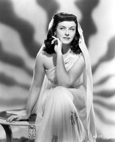 an old black and white photo of a woman in a wedding dress sitting on a bench