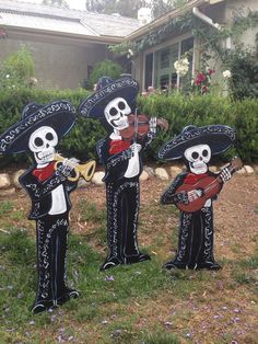 three skeletons playing instruments in front of a house