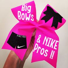 someone is holding up a pink bow with black and white lettering on it that says, big bows & nike pros