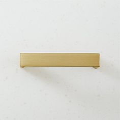 a brass cabinet handle on a white wall