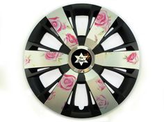 a black and white wheel cover with pink roses painted on the side, in front of a white background