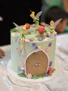 a cake decorated with tinkerbells and flowers