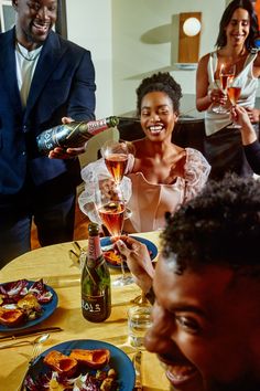 a group of people sitting around a table with food and drinks