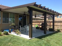 a covered patio with table and chairs in the back yard