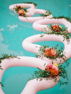 flowers are arranged on the side of an inflatable pool