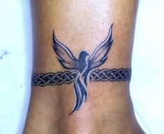 a woman's foot with a tattoo on the ankle that has a bird and braid