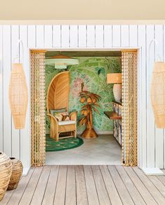 an open door leading into a room with tropical wallpaper