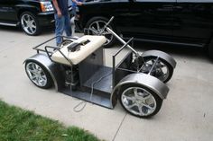 a man standing next to a small car on the sidewalk