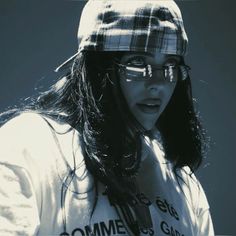 a woman wearing glasses and a plaid hat