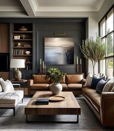 a living room filled with lots of furniture and large windows in the wall behind it