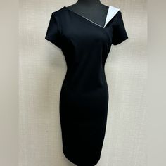 A Stylish Asymmetrical Neckline And Folded Contrasting Detail At The Left Shoulder Add A Unique Touch To This Sheath Dress. With A Convenient Back Zipper Opening, This Dress Is Easy To Slip Into, Ensuring A Seamless And Stylish Look For Any Occasion. Black/Vanilla Cold Water Wash Modern Asymmetrical Dress For Spring Formal, Formal Asymmetrical Dress With Short Sleeves, Chic Asymmetrical Midi Dress For Semi-formal Occasions, Asymmetrical Fitted Mini Dress For Formal Occasions, Elegant Asymmetrical Mini Dress For Work, Elegant Asymmetrical Short Sleeve Dress For Formal Occasions, Elegant Short-sleeved Asymmetrical Dress For Formal Events, Chic Asymmetrical Sheath Dress For Evening, Fitted One Shoulder Bodycon Dress For Work