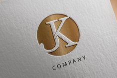 the letter k logo is made up of gold and silver foil on top of a white paper