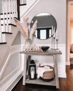 a table with a mirror, candles and other items on it in front of a staircase