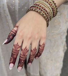 a woman's hands with hennap and bracelets on her wrist,