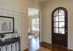 an entryway with wood floors and white walls