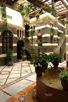 an indoor courtyard with potted plants and stairs