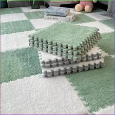 three pieces of green and white rugs sitting on top of a carpeted floor