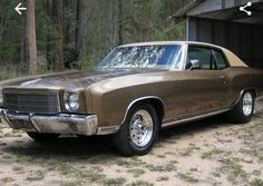 an old brown car parked in front of a garage with two arrows pointing to the right