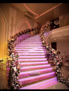 an elegant staircase decorated with flowers and greenery