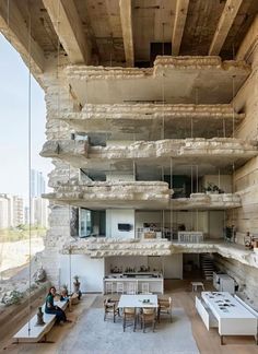 a living room filled with furniture next to a stone wall covered in hanging wires and suspended from the ceiling