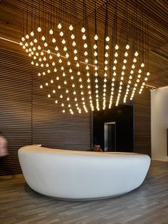 a large white bath tub sitting inside of a bathroom next to a wooden ceiling with lights hanging from it