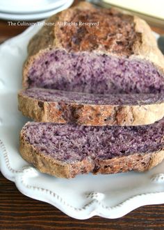 two slices of bread on a plate with purple stuff in the middle and one slice cut off