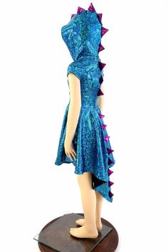 a mannequin wearing a blue dress with purple spikes on it's head