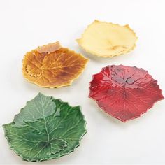 four leaf shaped dishes on a white surface