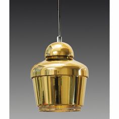 a gold colored pendant light hanging from a ceiling fixture on a gray background with no one in it