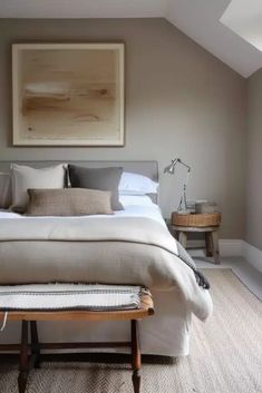 a large bed sitting under a painting on top of a wooden table in a bedroom