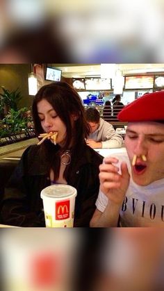 two people eating food in a fast food restaurant