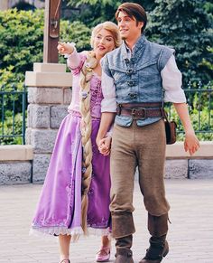 a man and woman dressed up as rappui and aurora from disney's frozen princess