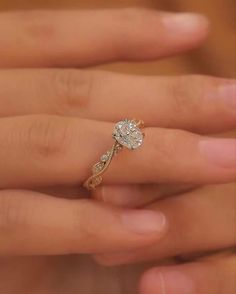 a woman's hand holding a ring with a flower on the middle of it