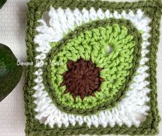 a crocheted square with a green leaf on it