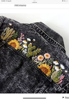 the back of a jean jacket with flowers embroidered on it