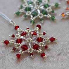 the beaded snowflakes are hanging on the tablecloth with other beads