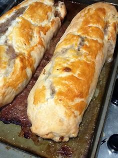 two long loafs of bread sitting on top of a baking pan next to each other