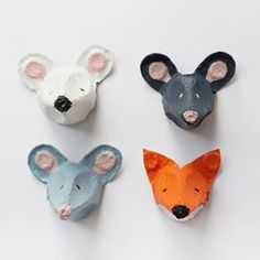 four different colored animal heads are shown on a white surface, one is grey and the other is orange