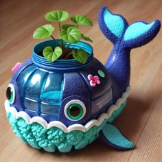 a blue whale shaped pot with a plant in it