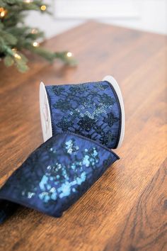 a roll of toilet paper sitting on top of a wooden table next to a christmas tree