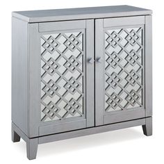 a gray cabinet with two doors and an intricate design on the front, sitting against a white background