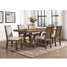 a dining room table and chairs with a rug on the floor in front of it