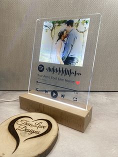 a wooden plaque with an image of a man and woman on it next to a photo frame