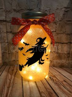 a lighted jar with a witch on it