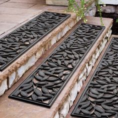 three black door mats sitting on top of stone steps