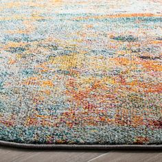 an area rug with various colors and patterns on the floor, including blue, yellow, orange